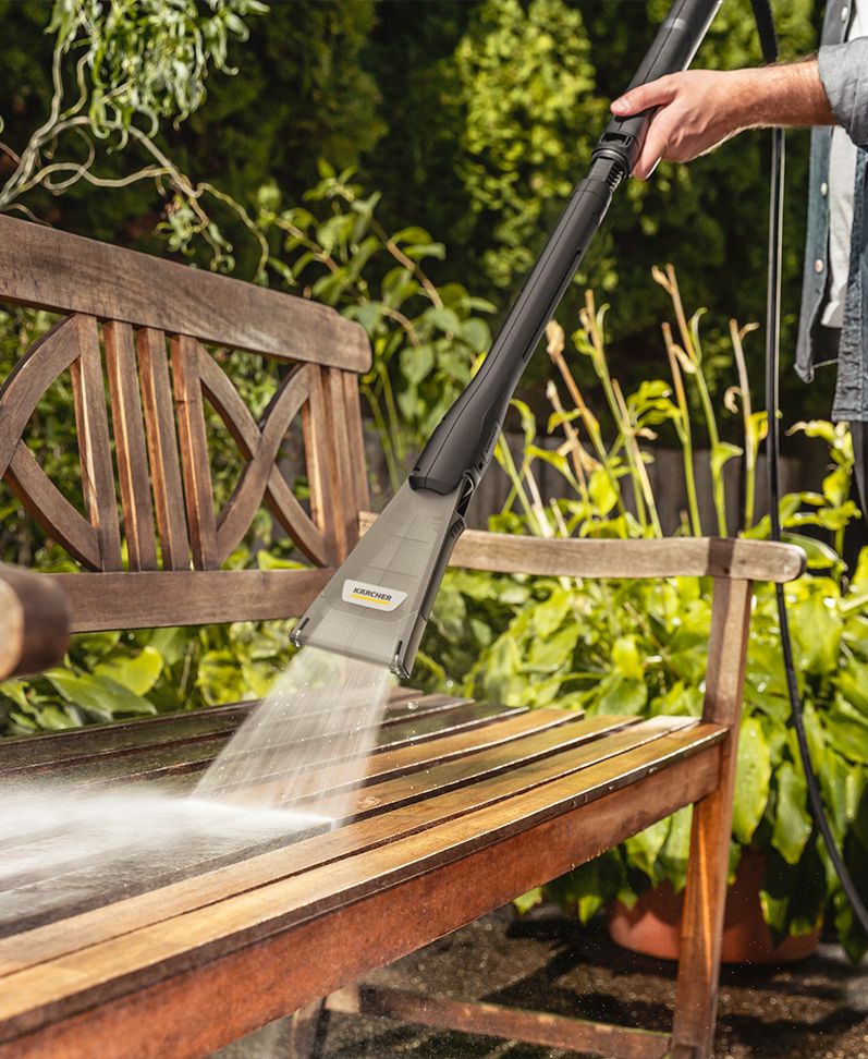 Holzbank wird mit Kärcher Hochdruckreiniger und eco!Booster-Zubehör gründlich gereinigt – effektive Außenreinigung für Gartenmöbel.